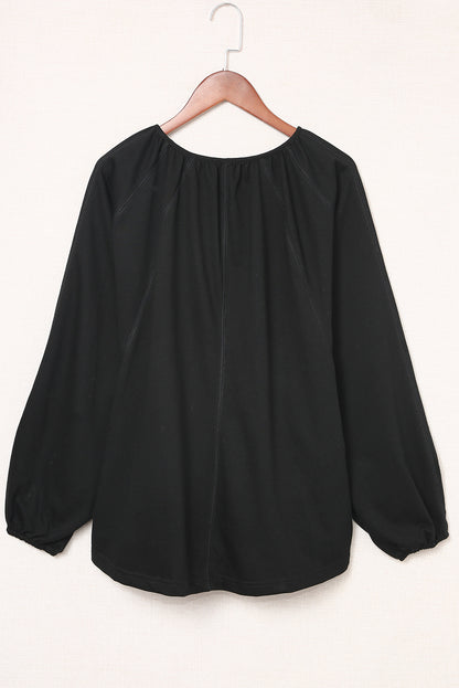 Blusa informal negra con cuello en V y detalle plisado