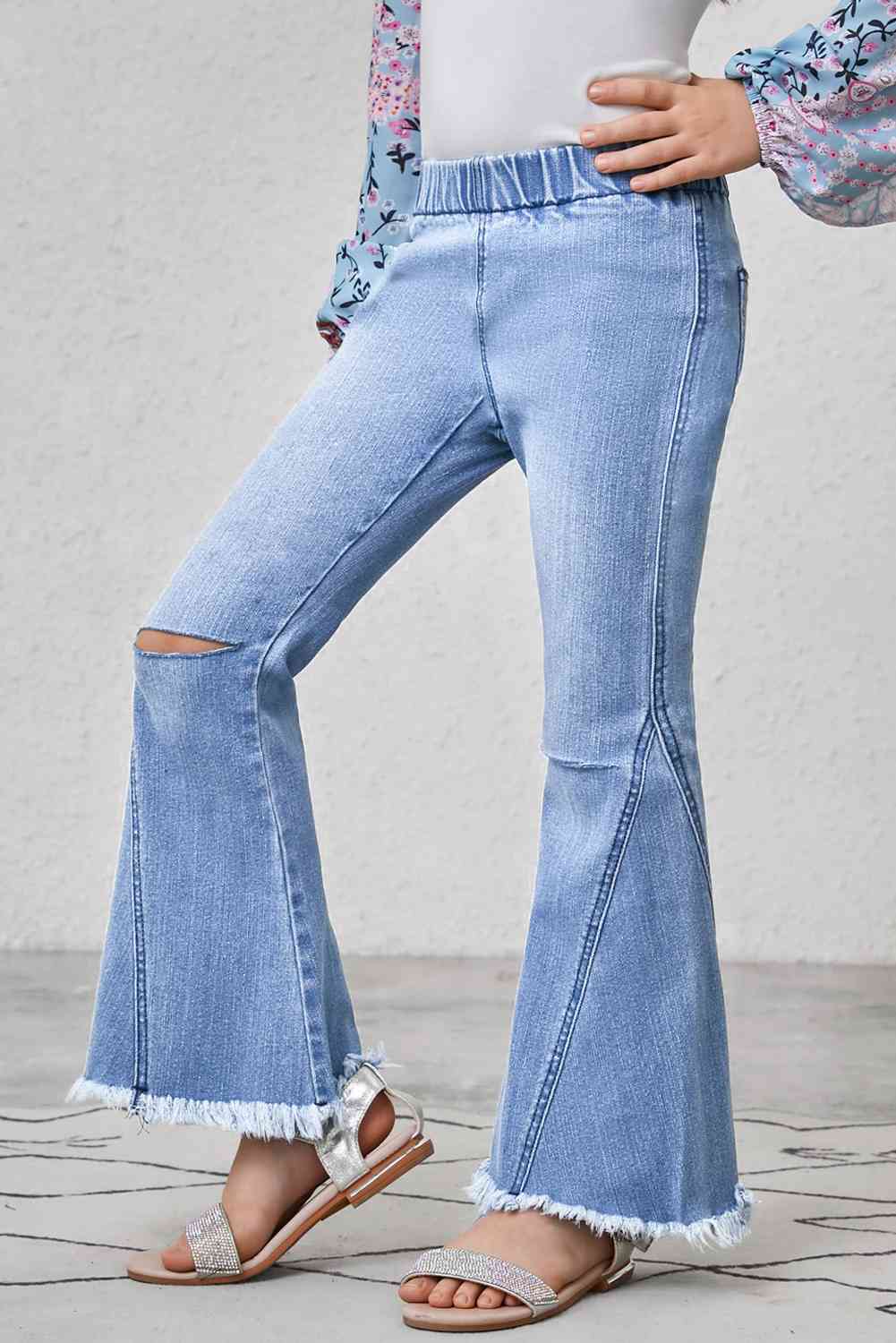 Jeans acampanados con ribete deshilachado y desgastados para niñas